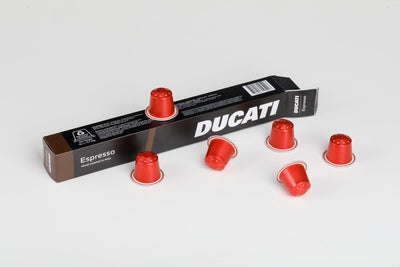 Espresso by Ducati box lying flat with red Nespresso® Original compatible capsules around it